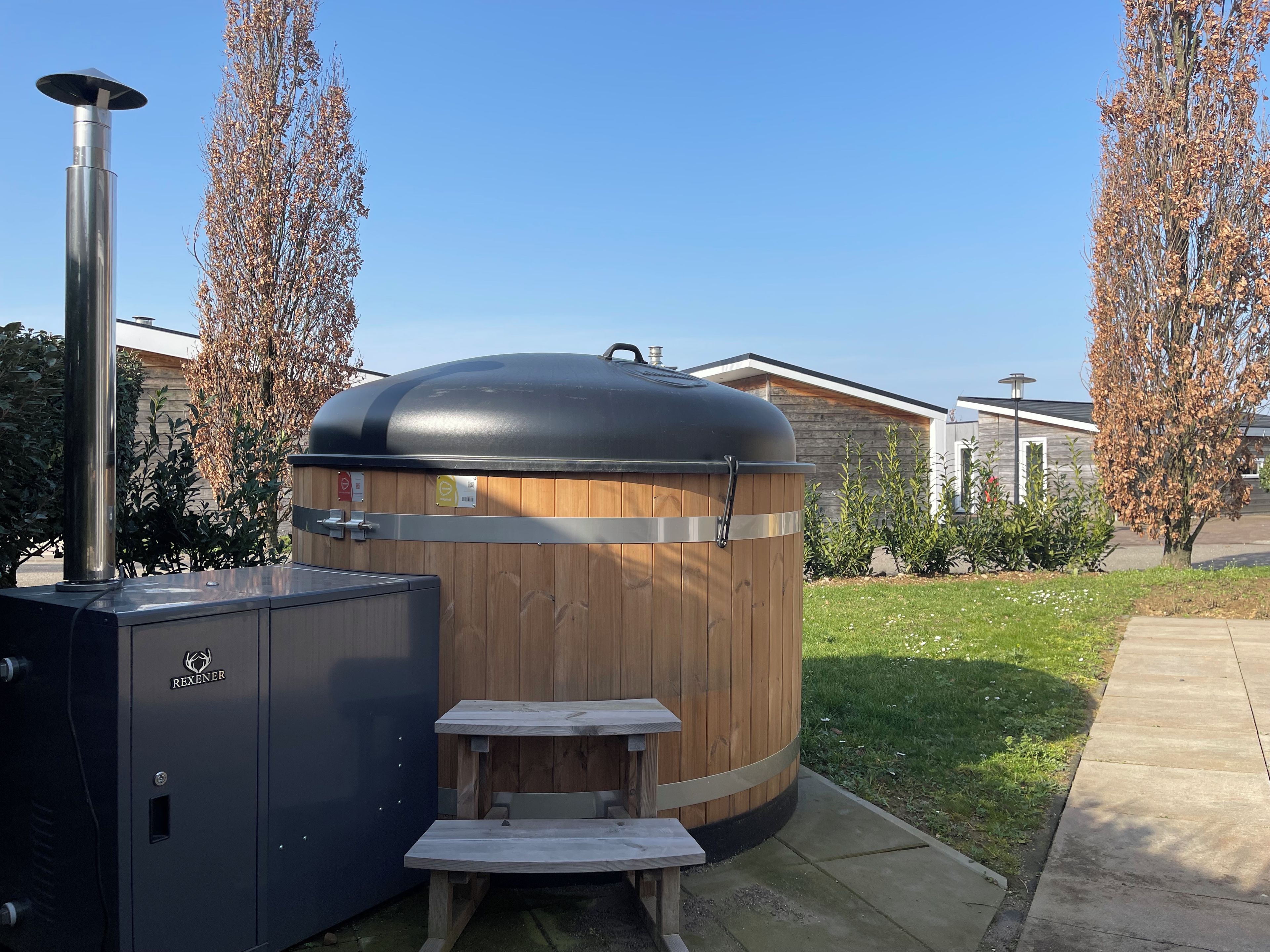 Ein Outdoor-Grill mit Holzoptik, inklusive Schornstein, Metallschrank und Holzbank.