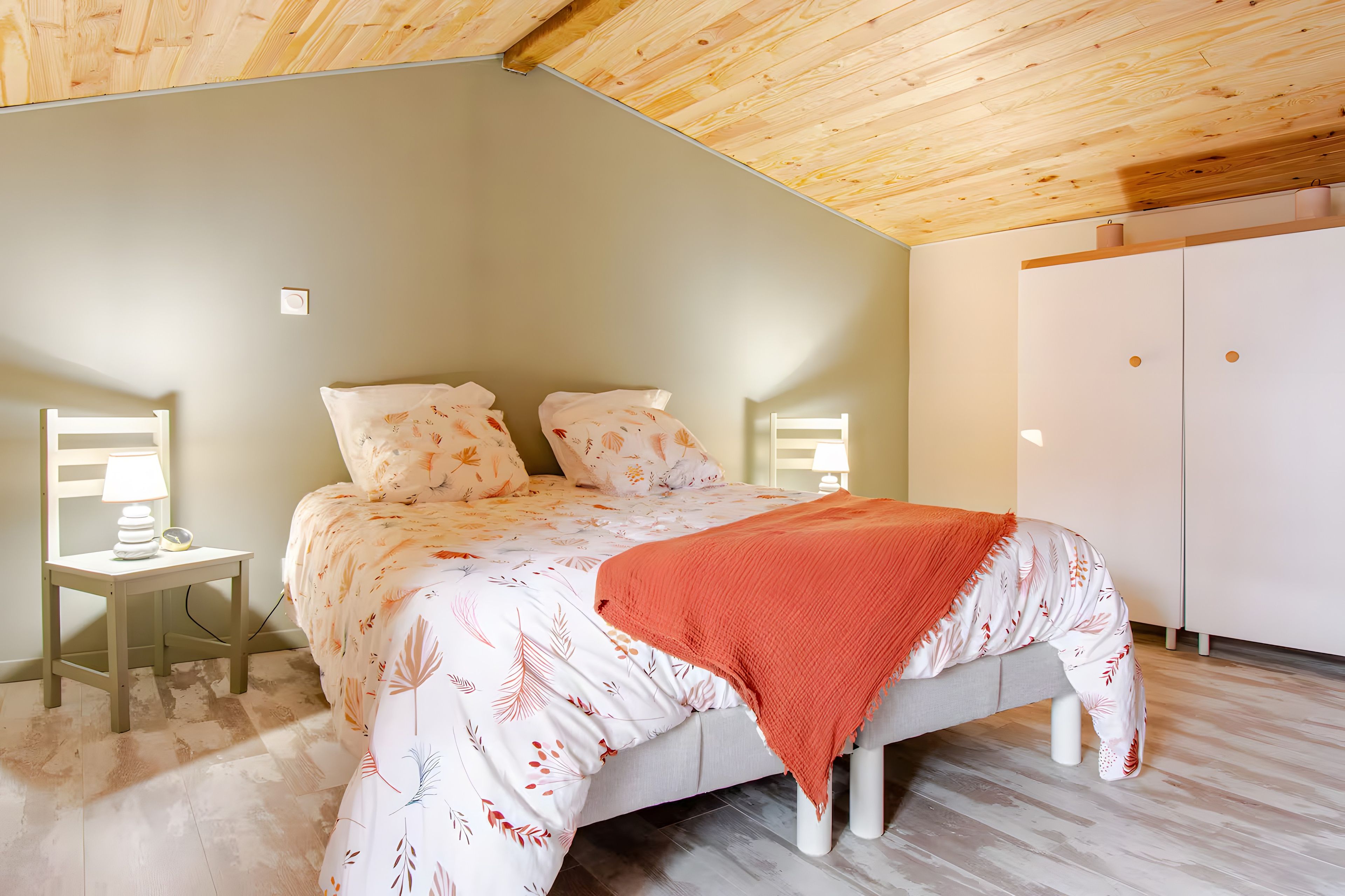 Una camera da letto con un letto, comodini, una lampada e un armadio.