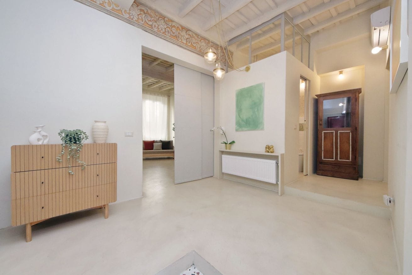 Un intérieur moderne avec un meuble en bois, un radiateur et un tableau abstrait vert accroché au mur.