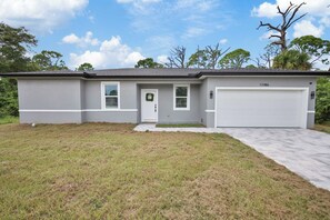 A single-story house with a garage, a front door, and a small porch. - Gulf Coast Escape | Spacious 4BR Home for 9 (Port Charlotte)
