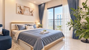 A modern bedroom with a large bed, a bedside table, a chair, and a potted plant. - Sweet Homes Tay Ho (Ha Noi)