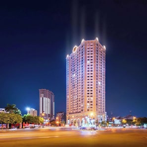 A high-rise building with multiple floors, a prominent entrance, and a well-lit facade. - Sweet Homes Tay Ho (Ha Noi)