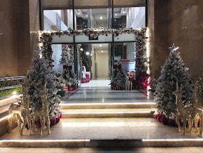A hotel entrance decorated with Christmas trees and reindeer statues. - Sweet Homes Tay Ho (Ha Noi)