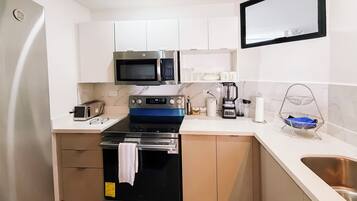 A compact kitchen with a microwave, oven, and toaster.