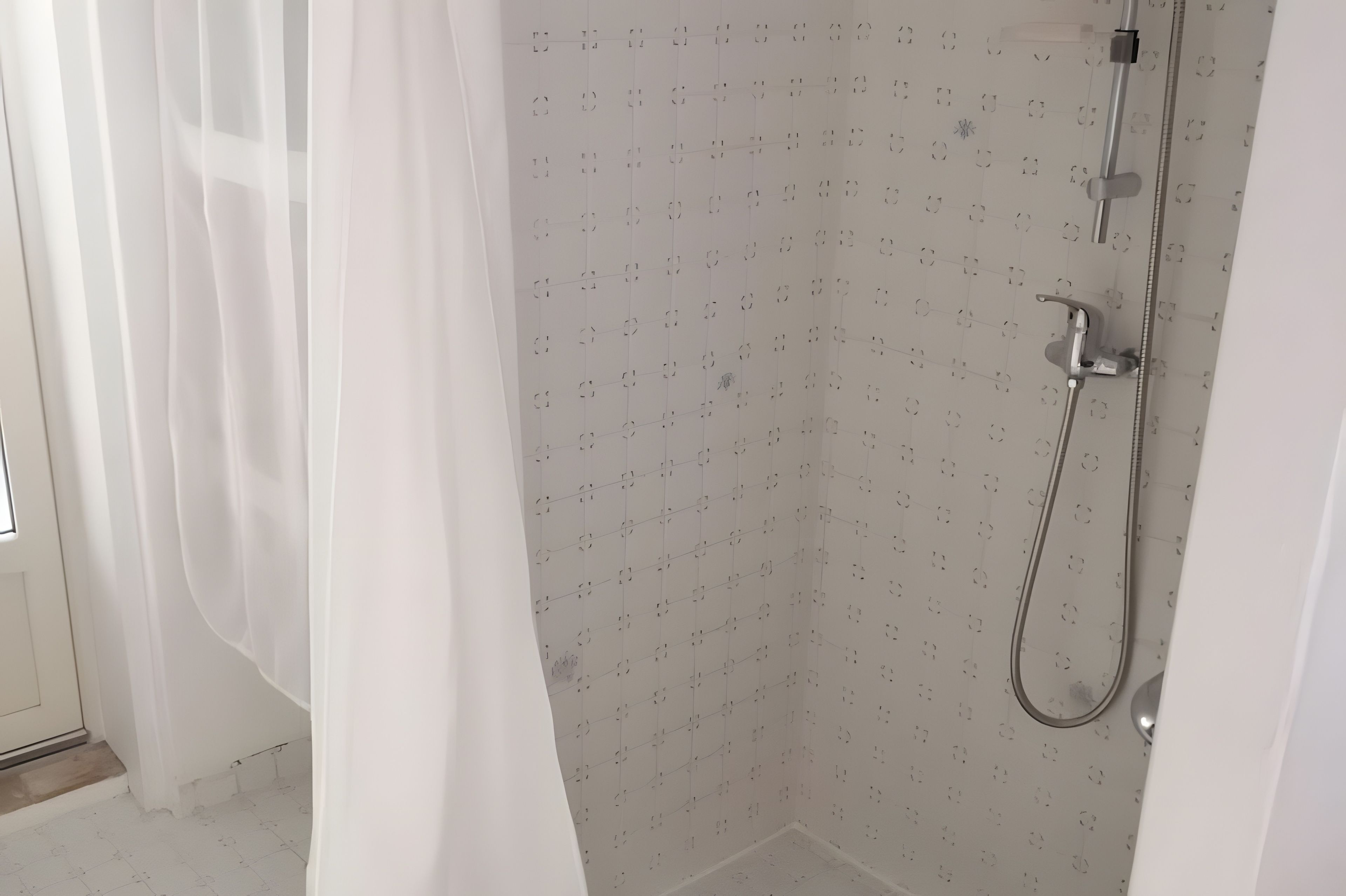 Un espace douche équipé d’un pommeau de douche et d’un rideau.