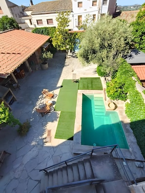A courtyard with a swimming pool, a small lawn, and a staircase leading to a building. - Room 'La Vinya' with Kitchen Access, Garden, Pool and Wi-Fi (Sant Martí de Maldà)