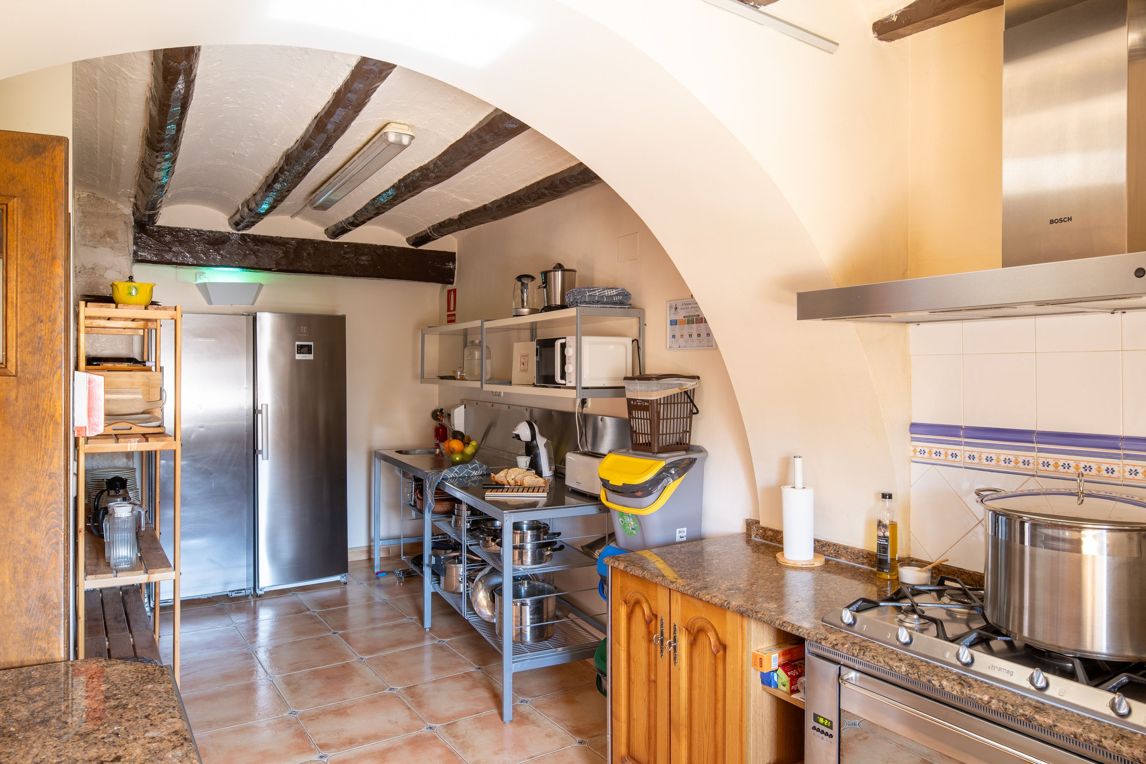 Una cocina con un refrigerador de acero inoxidable, una estufa a gas y un microondas.