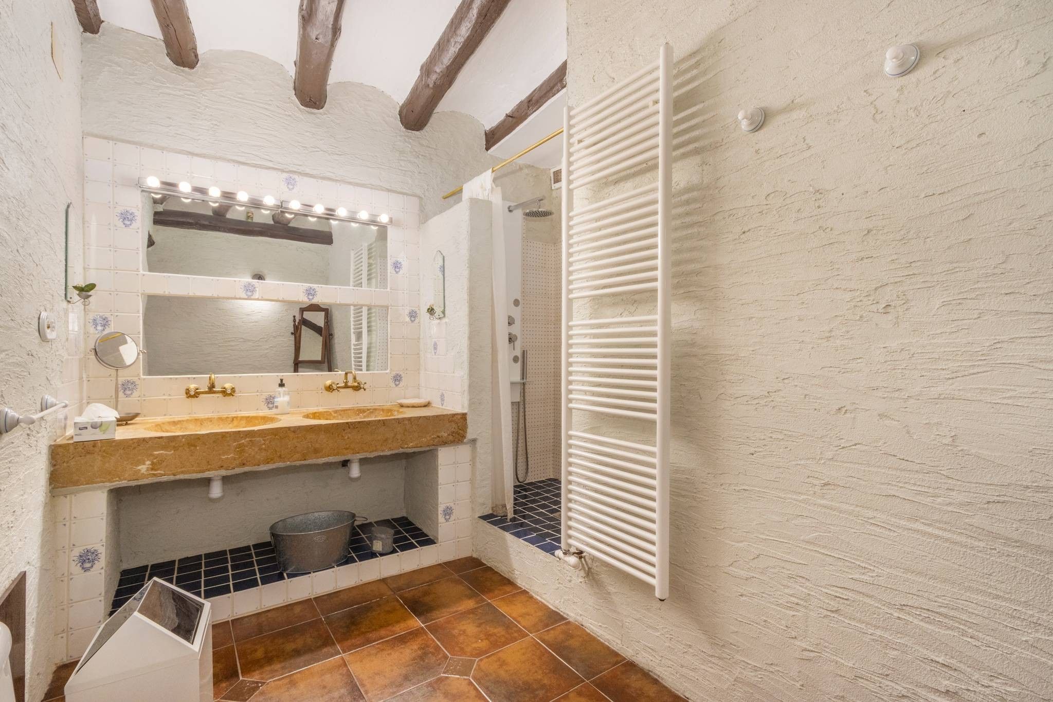 A bathroom with a vanity, mirror, and shower.