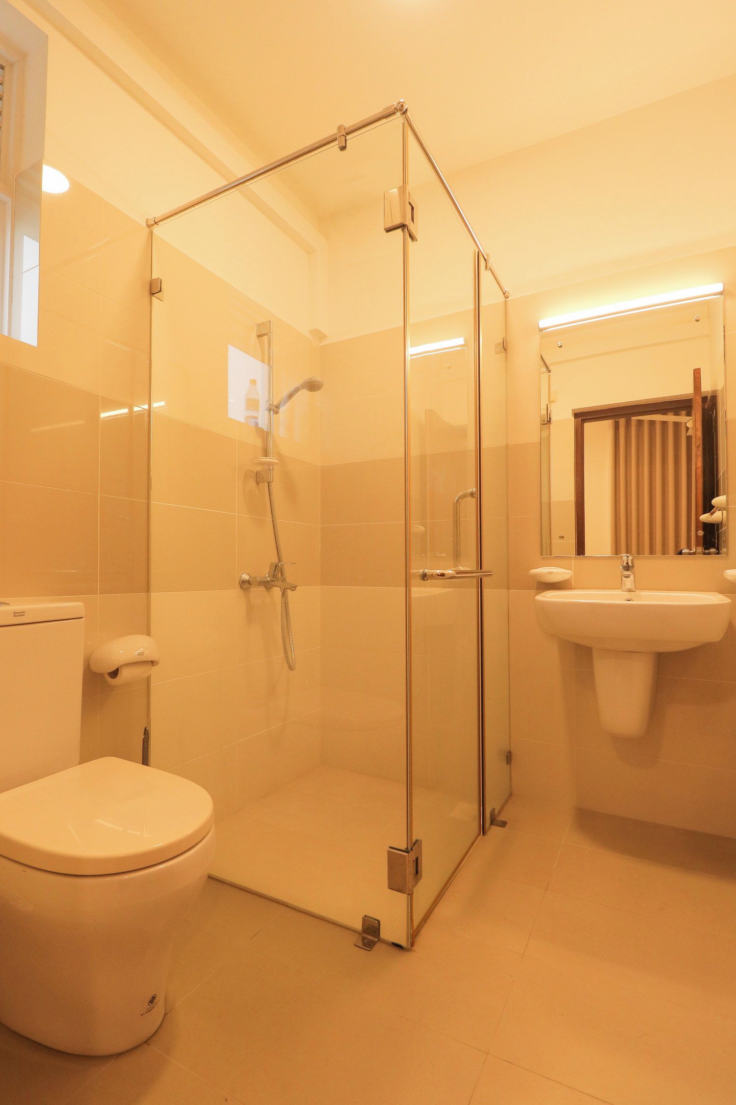 A modern bathroom with a glass-enclosed shower, a toilet, and a sink.