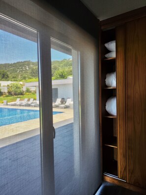Ein Zimmer mit Blick auf ein Schwimmbad und Liegestühle.