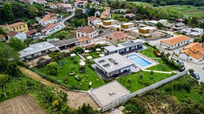 A residential area with houses, a swimming pool, and a well-maintained garden. - Tiny Home 'Casa Verde' with Sea View, Shared Pool and Wi-Fi (Cristelo)