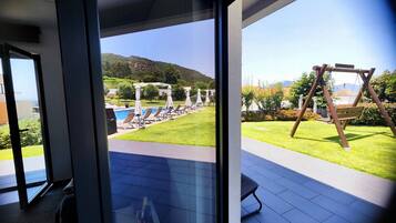 Un área exterior moderna con piscina, sillas de descanso y un columpio.