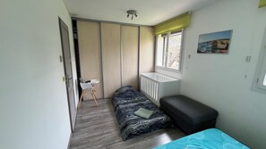 A compact room with a bed, a small table, a window, and a radiator. - New Listing (Velaux)