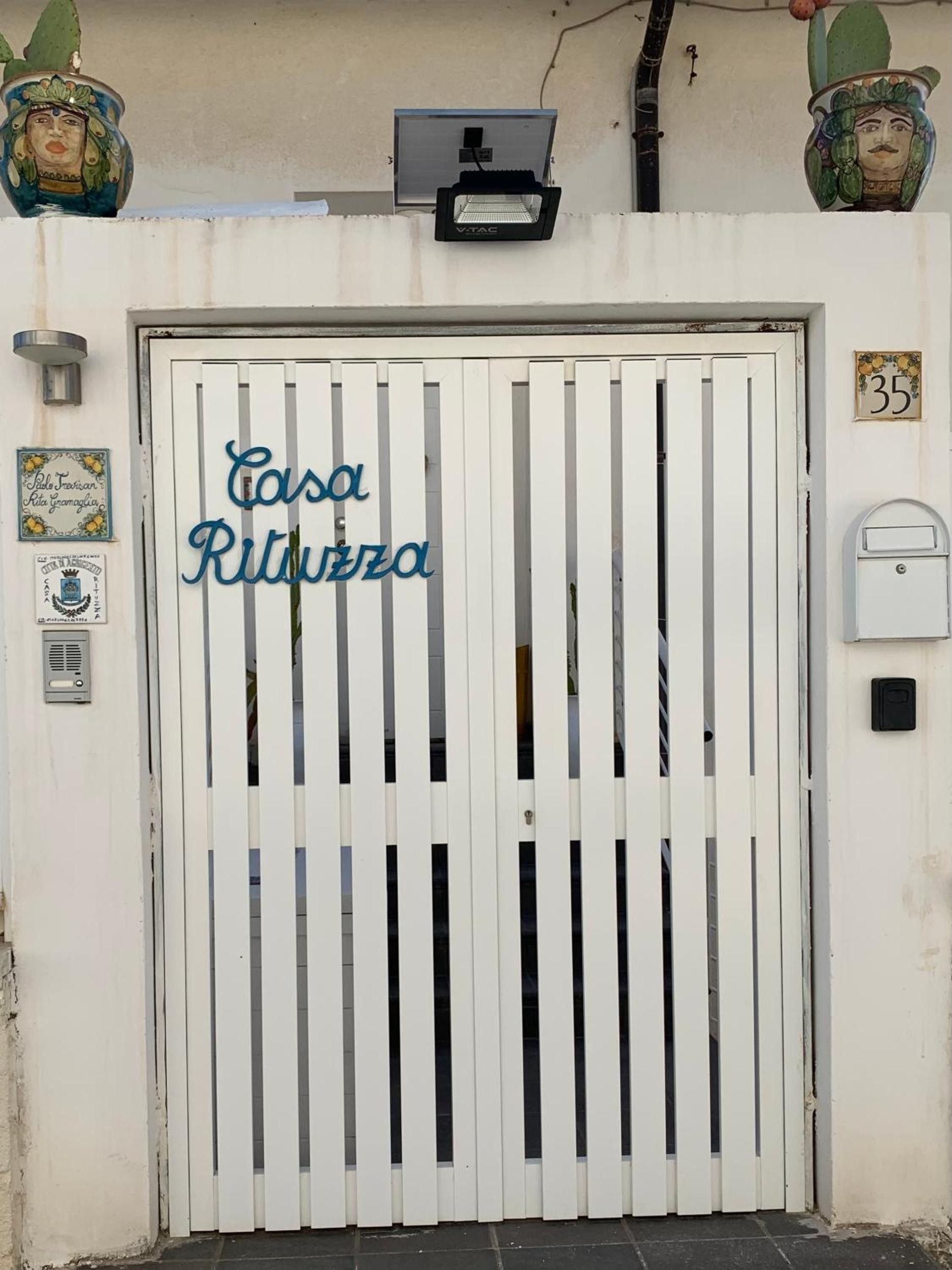 Une porte blanche sur laquelle on peut lire en lettres bleues l’inscription « Casa Ritazza ».