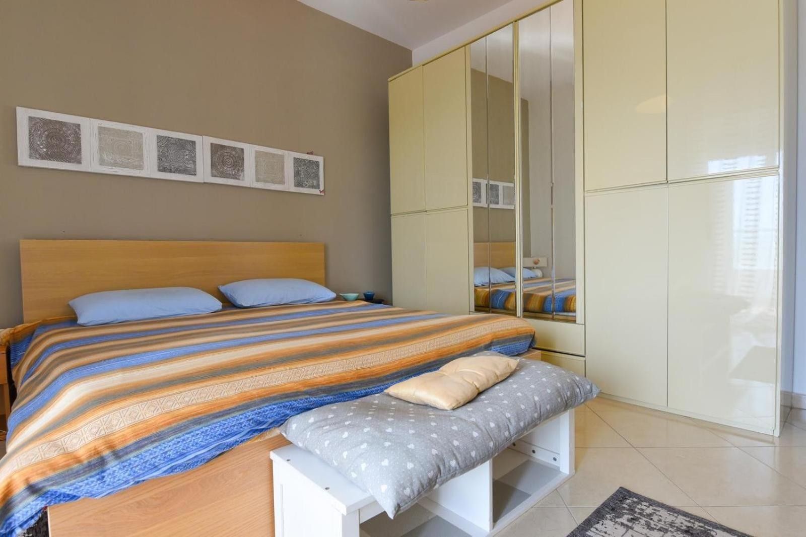 A bedroom with a bed, bedside table, and a wardrobe.
