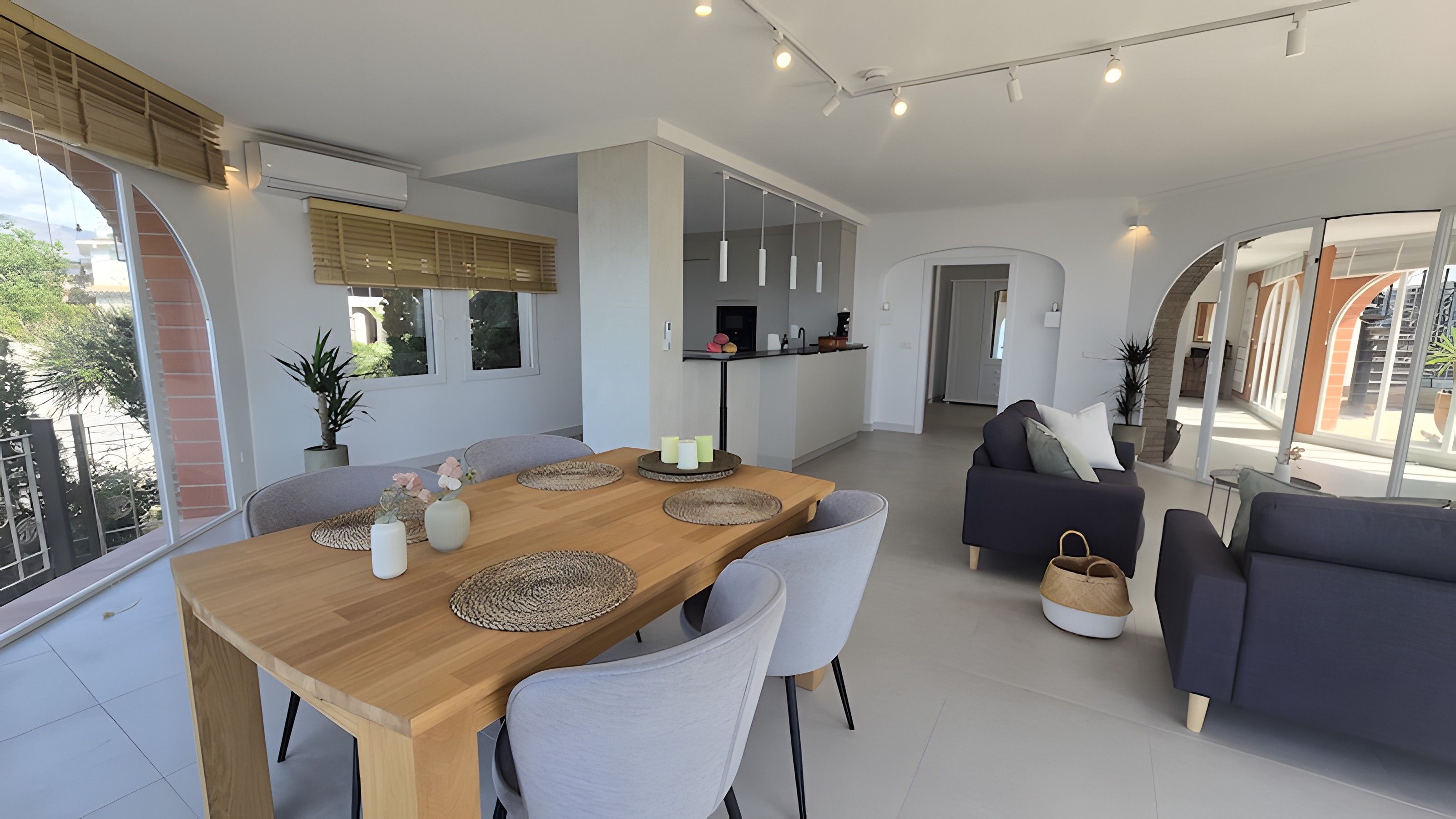 Un espace de vie moderne comprenant un coin repas, des canapés et une cuisine.