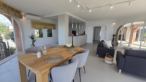 Een moderne woonruimte met een eethoek, banken en een keuken.
