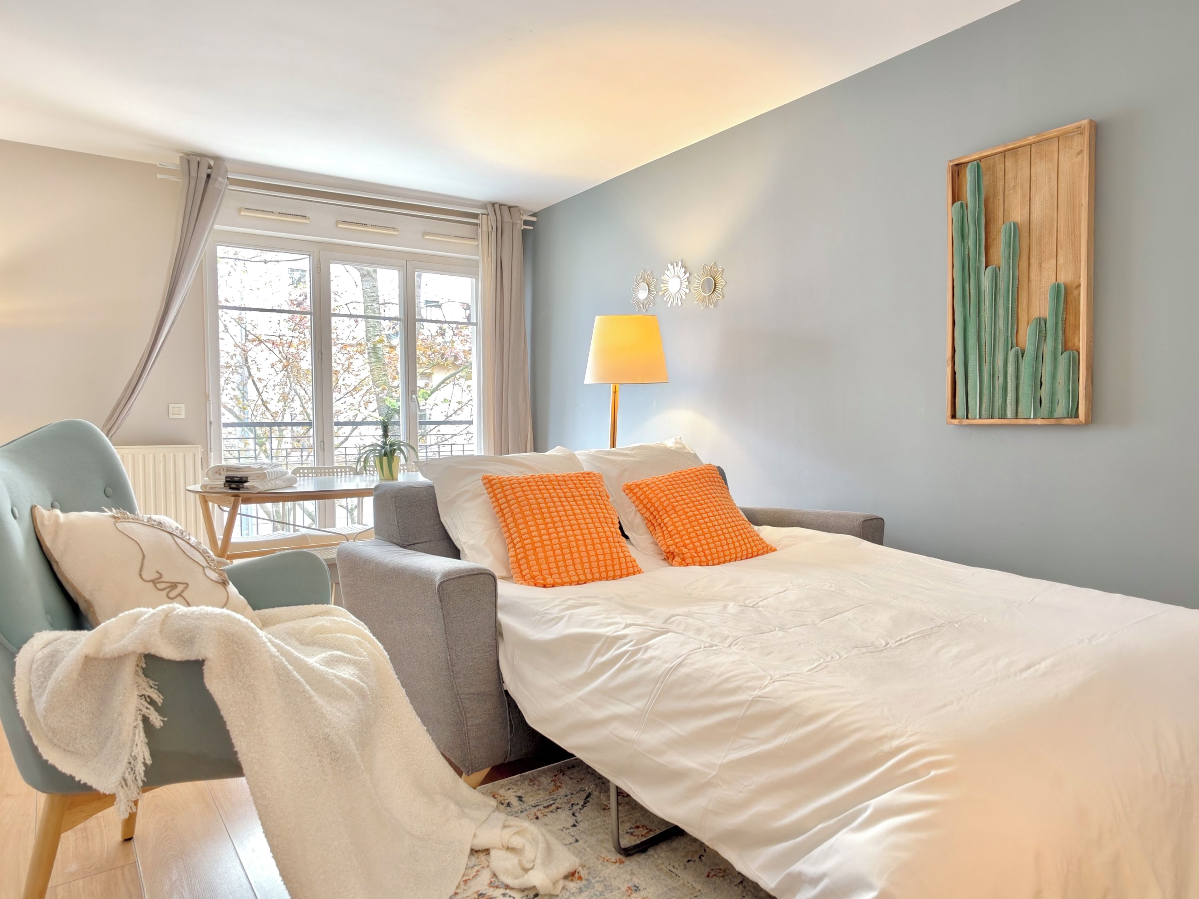 Een hotelkamer met een bed, een stoel, een tafel en een raam.