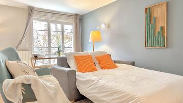 Een hotelkamer met een bed, een stoel, een tafel en een raam.
