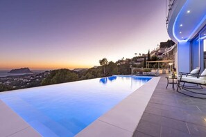 An infinity pool with a view of the landscape and distant buildings.