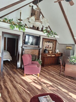 Uma sala de estar aconchegante com lareira, televisão e um espaço de estar confortável.
