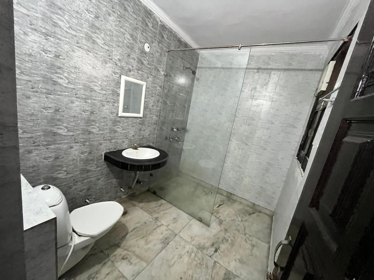 Un baño con inodoro, lavamanos y ducha.