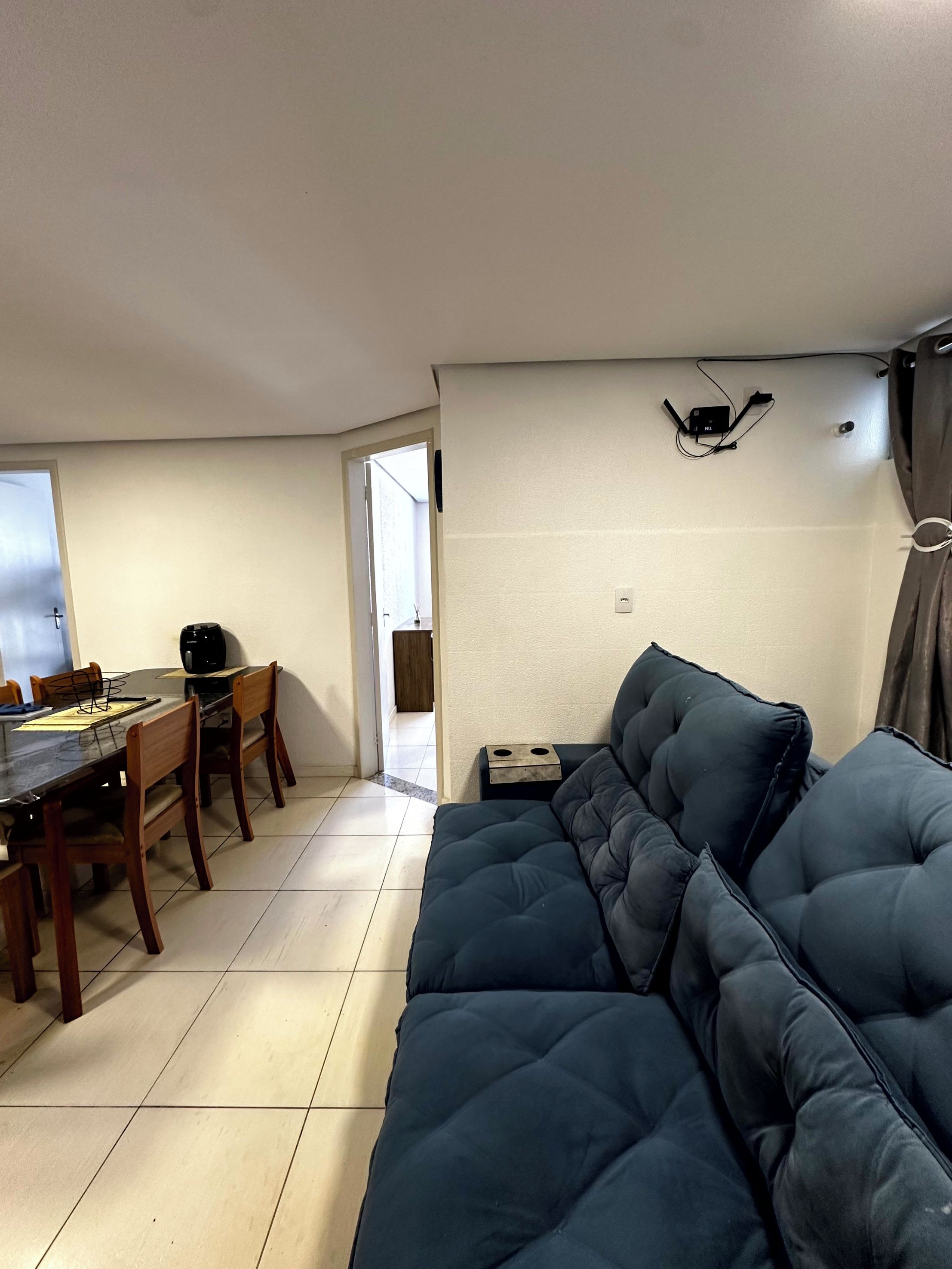 A living area with a sofa, a dining table with chairs, and a small side table.