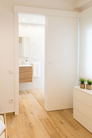 Une salle de bain moderne avec un meuble-lavabo en bois, un miroir et une serviette accrochée au mur.