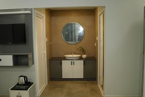 A modern bathroom with a round mirror, a sink, and cabinets. - CLOUDWOOD RESORT (Sulthan Bathery)