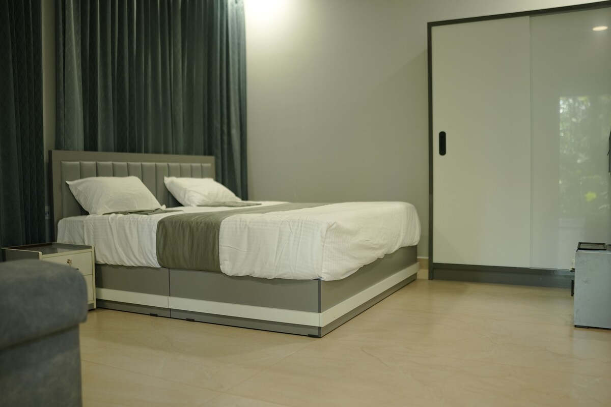 Quarto moderno com cama, mesa de cabeceira e guarda-roupa.