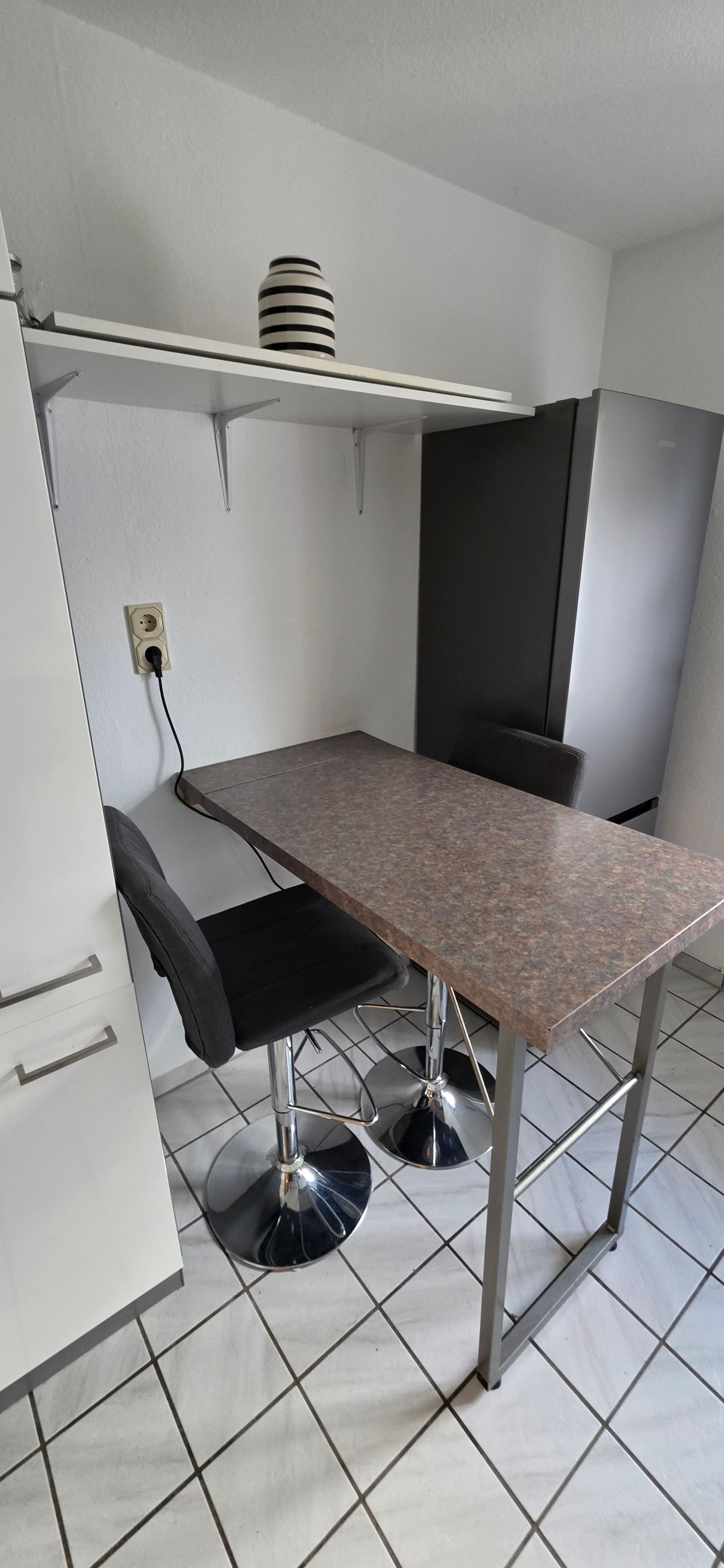 Een kleine keuken met een aanrecht, een spoelbak en een kookplaat.