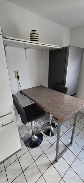 A small kitchenette with a countertop, a sink, and a stove.