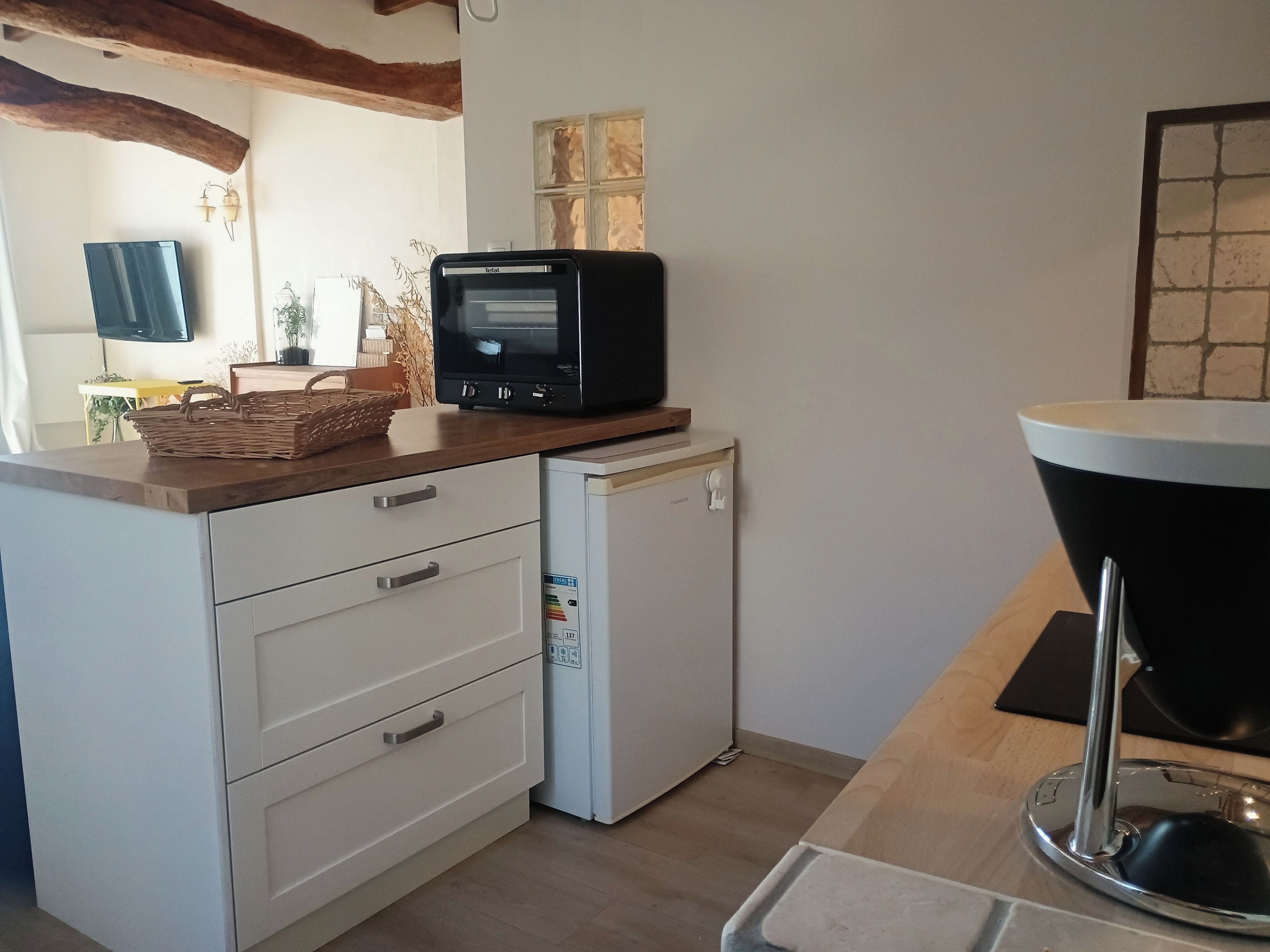 Une cuisine compacte équipée d’un four à micro-ondes, d’un petit réfrigérateur et d’un évier.
