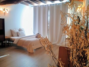 A bedroom with a bed, a nightstand, a lamp, and a window with curtains. - New Listing (L'Isle-sur-la-Sorgue)