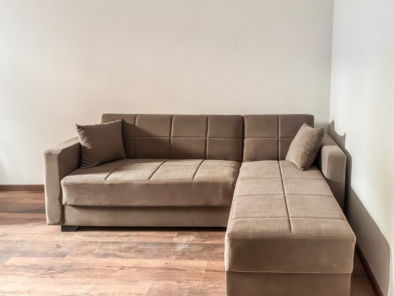 Un sofà modular en una habitació amb terra de fusta.