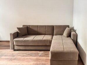 A sectional sofa in a room with wooden flooring.
