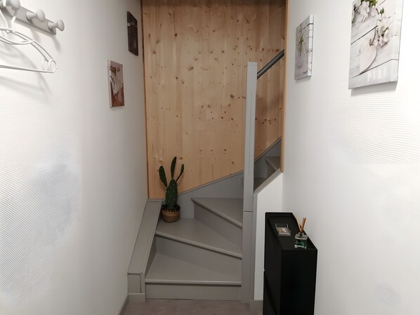 Een trap met een houten wand en een cactus op de landingsplaats.