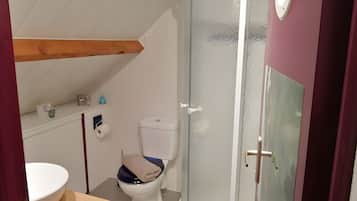 A bathroom with a white toilet, a sink, and a shower enclosure.