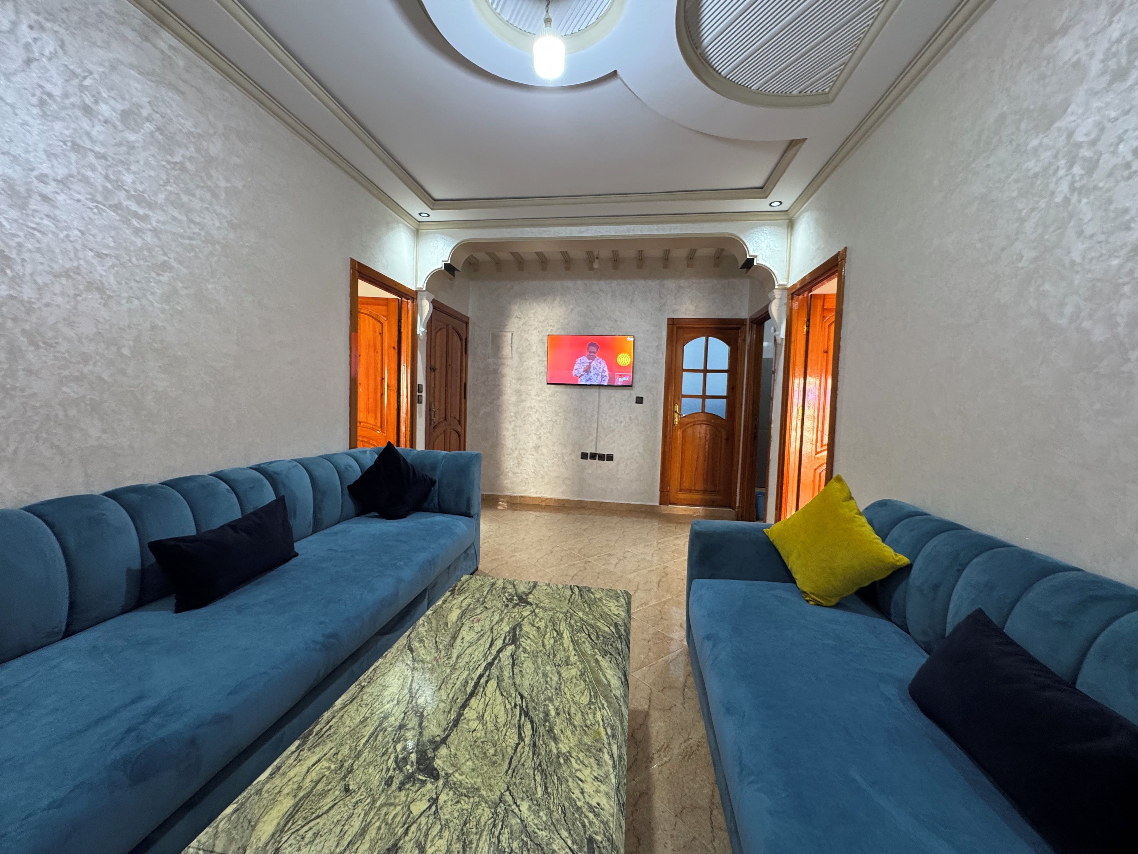 A living room with two sofas, a coffee table, and a TV mounted on the wall.
