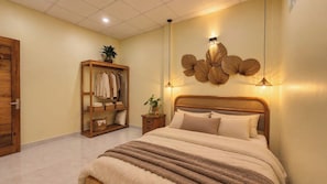 Un dormitorio con cama, armario, lámpara de pared y una mesita con una planta.
