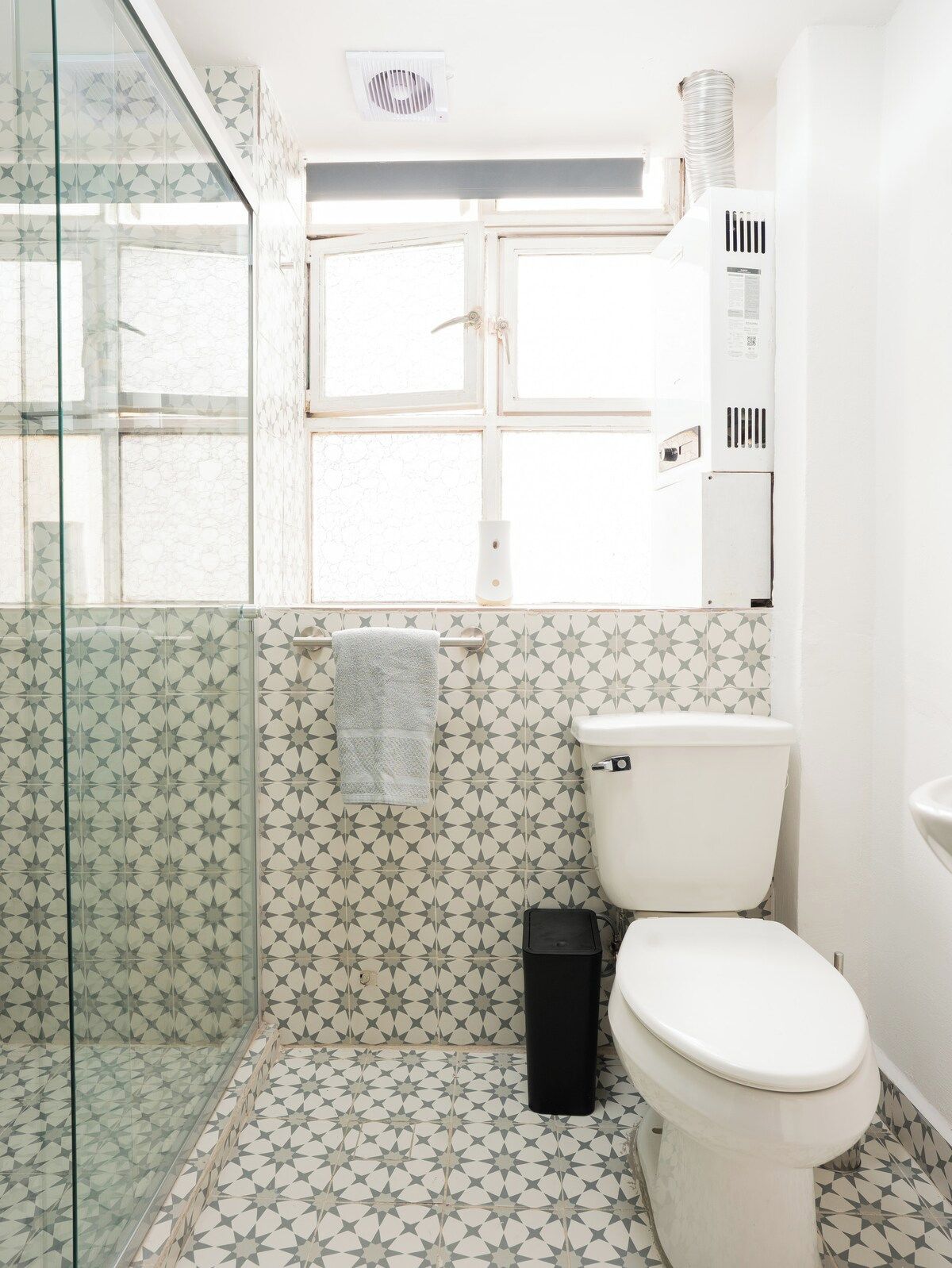Ein Badezimmer mit Duschkabine aus Glas, Toilette und Waschbecken.