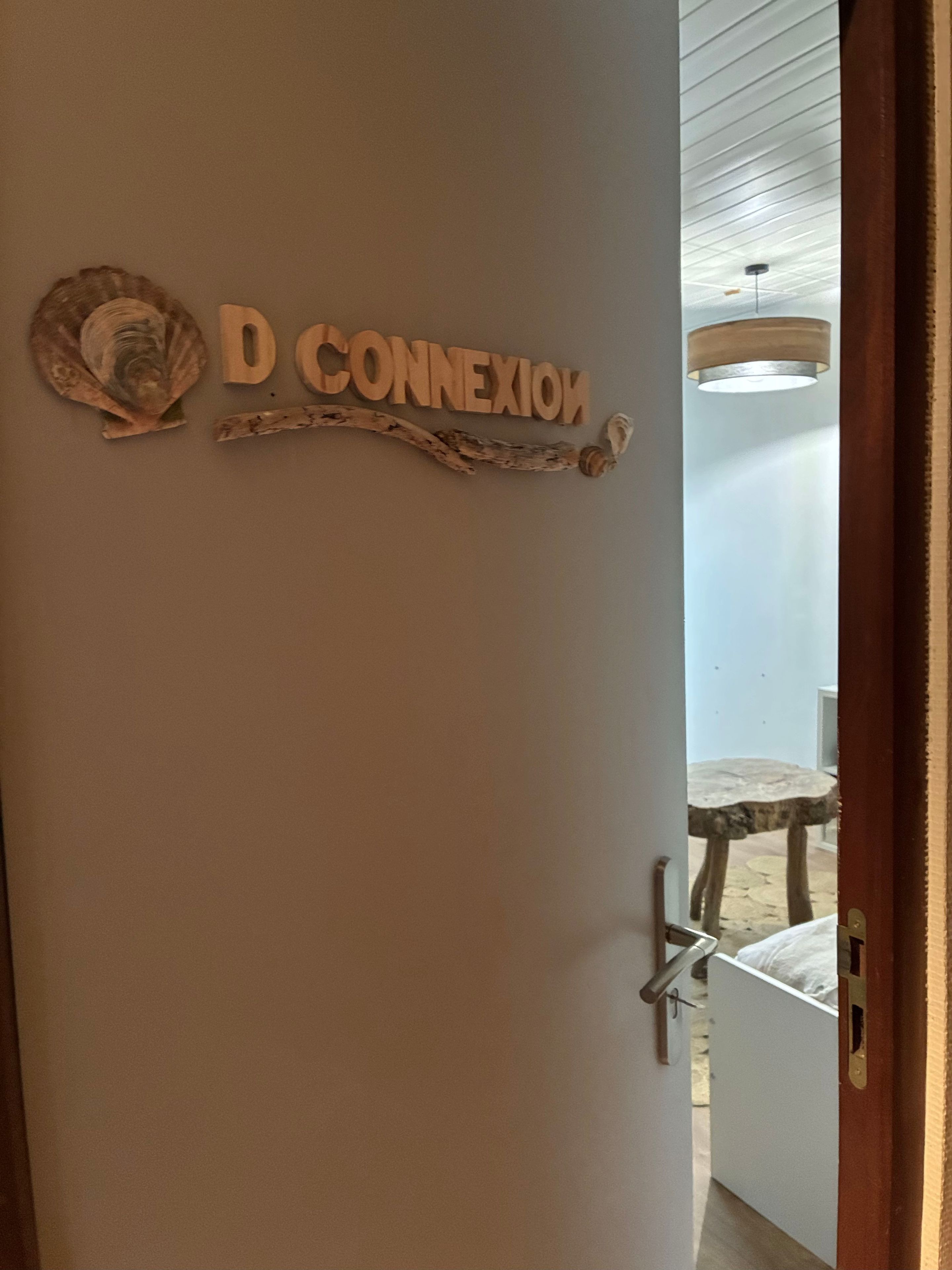 Une porte sur laquelle est apposée une plaque indiquant « D CONNECTION », ainsi qu’un élément de décoration rustique.
