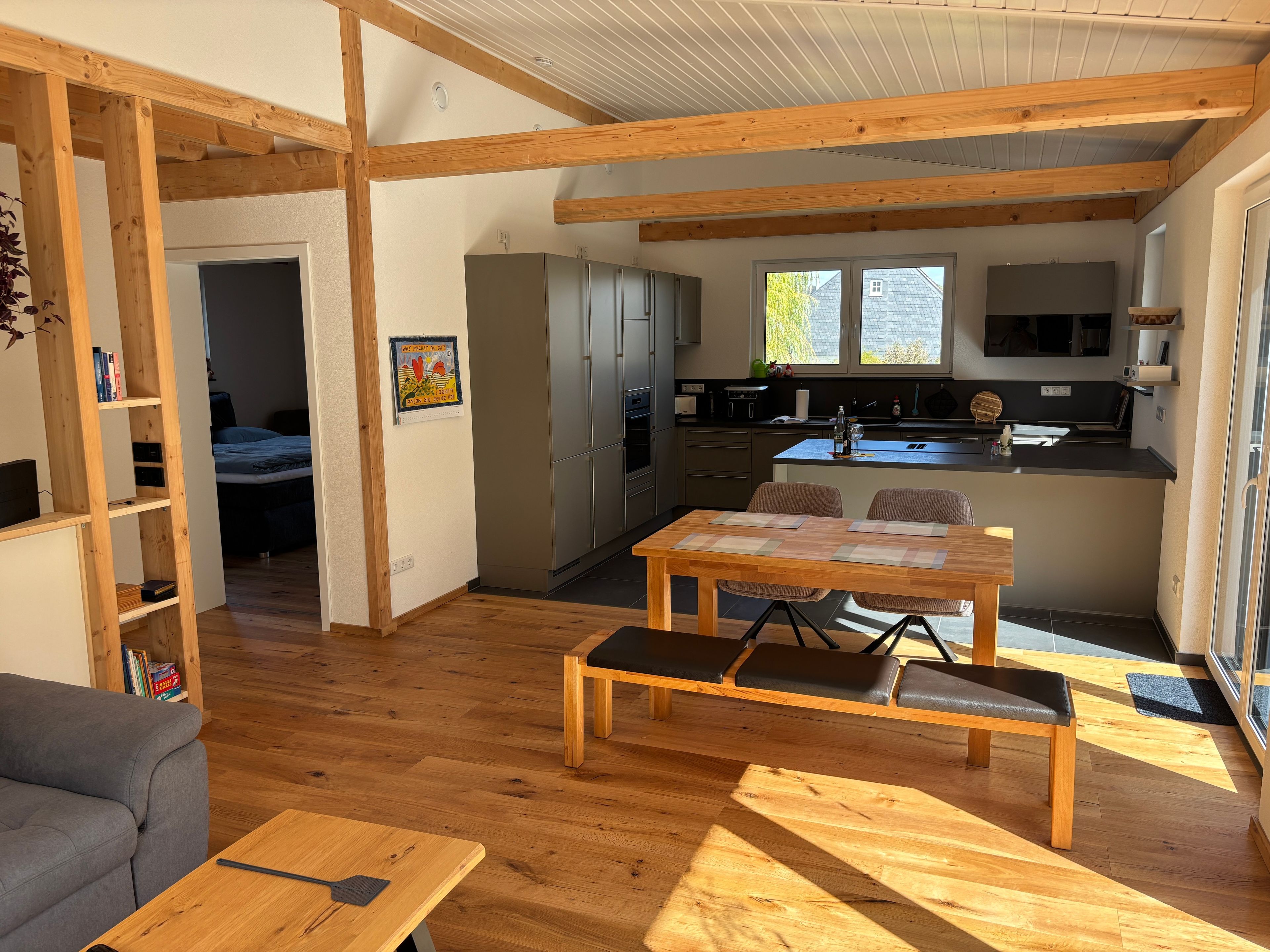 Un espace de vie compact comprenant un coin repas, une kitchenette et un espace nuit séparé.