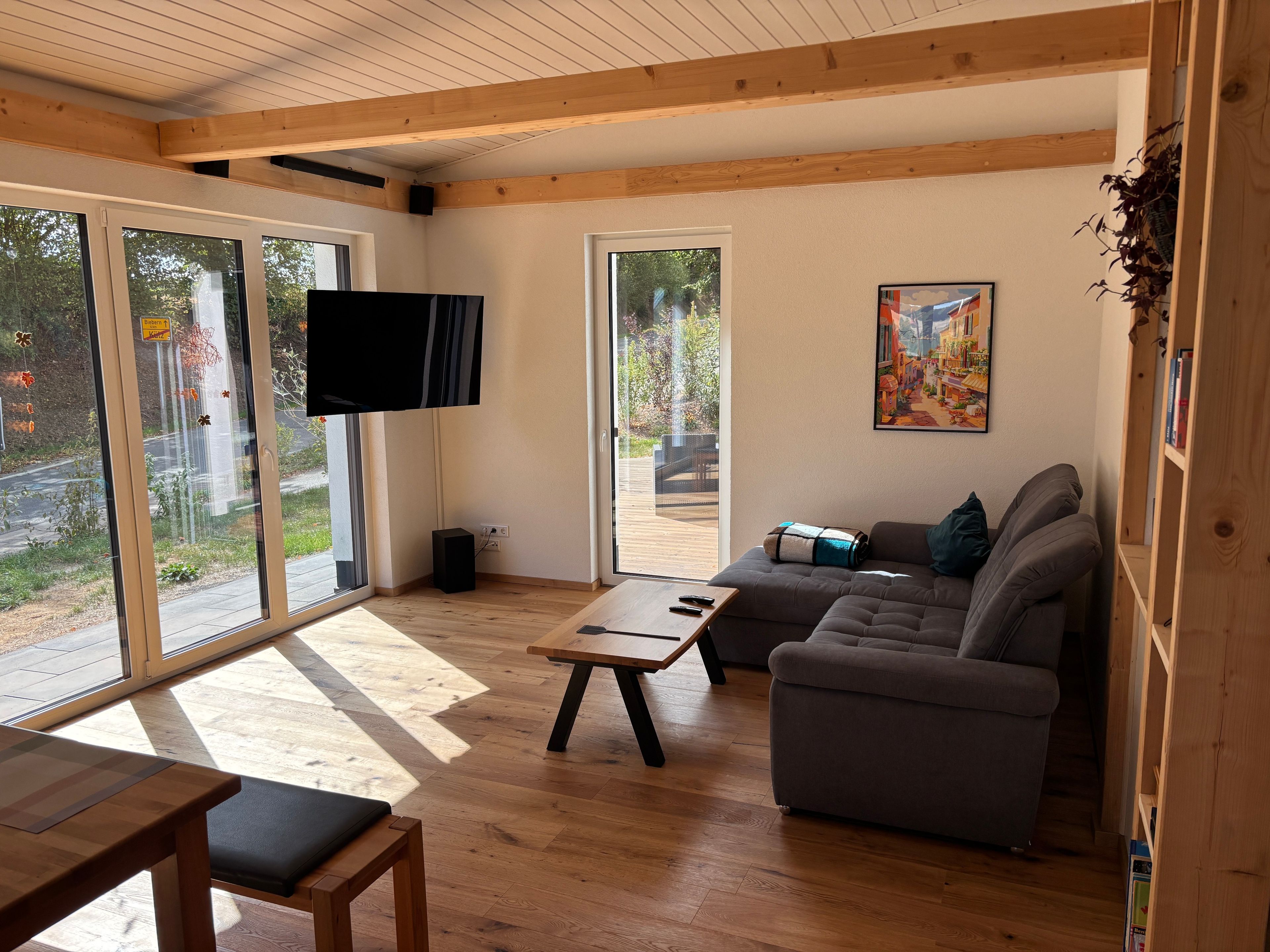 A modern living room with a sofa, a coffee table, and a TV mounted on the wall.
