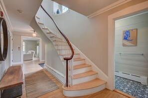 A staircase with a wooden handrail leading to a landing. - Upscale 5BR | Walk to Dining + Downtown (Conway)