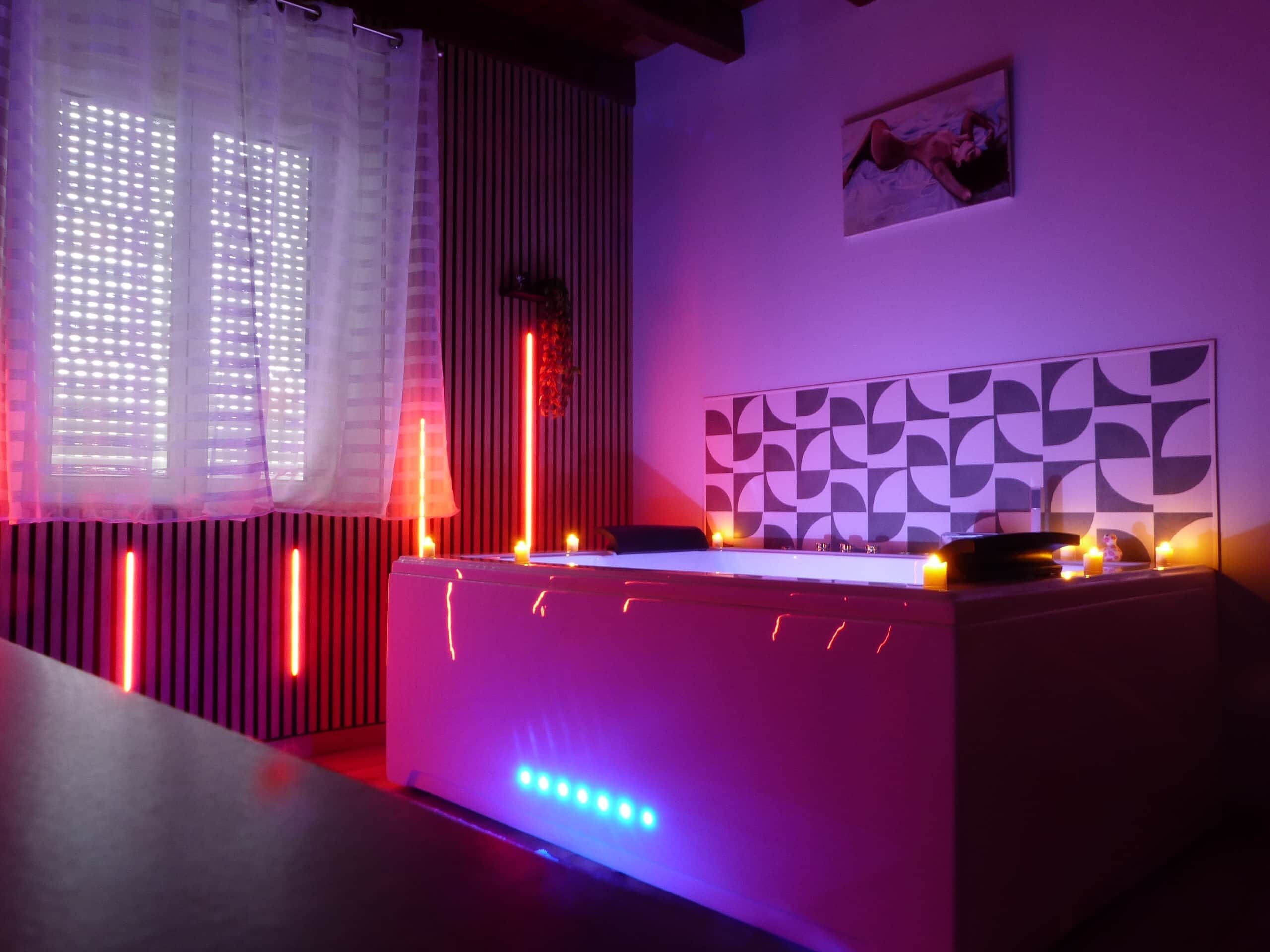 Une pièce dotée d’une table de billard, d’un éclairage d’ambiance et d’un mur orné de motifs.