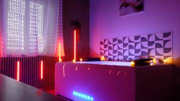 Une pièce dotée d’une table de billard, d’un éclairage d’ambiance et d’un mur orné de motifs.