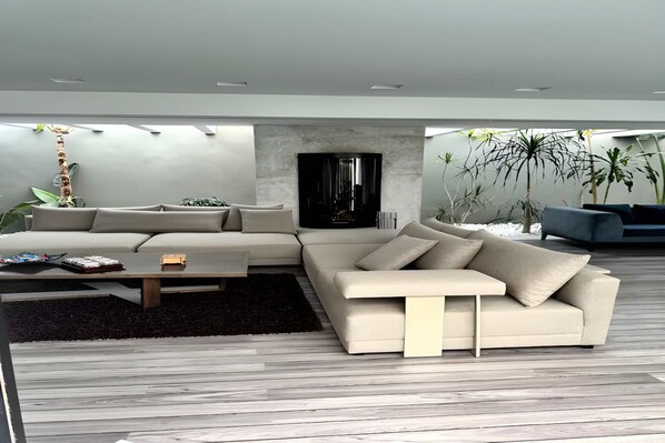 Una sala de estar moderna con un sofá modular, una mesa de centro y un televisor de pantalla plana contra la pared.