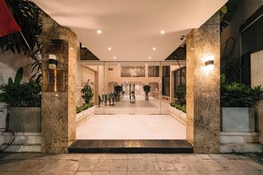 A hotel entrance with a reception desk, seating area, and potted plants. - Park Haven Hotel (Ha Noi)