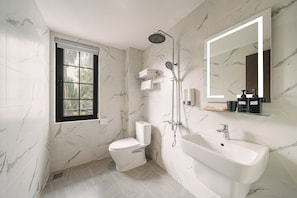 A bathroom with a toilet, shower, sink, and a window. - Park Haven Hotel (Ha Noi)